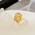 Macro shot of 18K gold plated multi-layer spiral ring on minimalist podium display - Spiral Opening