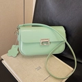 Chic mint green crossbody bag with silver buckle and floral tag on art books - Green