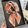 Elegant floral silk scarf in retro orange displayed on a tray with fashion accessories - 65x65cm / Orange Pink