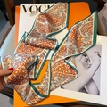 Detail eines Seidenschals mit Paisley-Muster auf Magazin und orangefarbener Box - Orange Weiß Paisley (Aquagrüner Rand)
