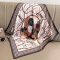 Elegant houndstooth silk scarf with floral camellia print displayed on leather sofa - Coffee Edge