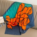 Detail of vibrant camellia silk scarf with orange and blue floral pattern on leather - 70*70cm / Blue and Orange