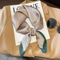 Lilac silk scarf with geometric G patterns and green edges on a fashion magazine - Purple