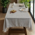 Nappe en lin gris avec pompons crème sur une table à manger en bois foncé - 140*100 / Gris