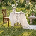 White floral lace round tablecloth with elegant embroidery in an outdoor garden setting - French Peony Ruffle - White
