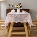 Mantel de encaje floral rosa con borlas blancas en una mesa de comedor de madera - 130x260cm / Punto de Nieve Rosa