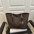 Sac cabas en cuir marron avec imprimé lettre M et pendentif doré sur chaise - café
