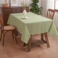 Green and white checkered linen placemat with raw edges on a wooden dining table - Green Gingham