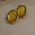 Close-up of vintage oval amber resin earrings with gold-plated geometric metal edges - Gold Plated Amber Wave (E0501)