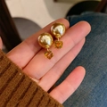 Macro detail of French style gold pearl stud earrings with amber cube pendant on hand - E1664 Amber Square Pearl / Amber / Champagne Pearl