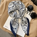 Eleganter Seidenschal in Marineblau und Creme mit Rosenmuster auf braunem Blazer - Marineblaue Kante