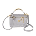 Elegant grey snake pattern vanity bag with gold handle and decorative charms - Silver