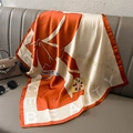 Elegant orange silk square scarf with pearl and bow prints on a leather sofa surface - 70x70cm / Orange