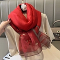 Detalle del pañuelo de seda roja con bordados florales y bordes metálicos brillantes - Rojo