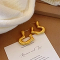 Close-up of matte gold irregular heart earrings on white card with knit background - Matte Gold (Bamboo Heart)