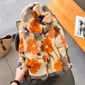 Katoenen linnen sjaal met bloemenprint in oranje en beige op een leren stoel - Oranje