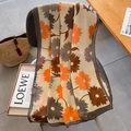 Sciarpa artistica con stampa floreale beige e arancione drappeggiata su una sedia scura - Beige Arancione
