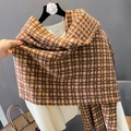 Dettaglio di sciarpa a quadri morbida con frange sopra un maglione di maglia bianca - Quadri Caffè Arancione