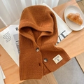 Detailed knit texture of brown buttoned balaclava hat on a rustic wooden table - Caramel color