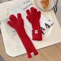 Detalle de guantes de punto rojos con textura acanalada y etiqueta de diseño en puño - Talla única / Rojo