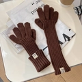 Detail of brown ribbed knit gloves with decorative white label on a styled background - One Size / Coffee