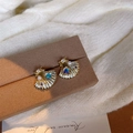 Detailed view of ocean shell earrings with gradient pearls and heart-shaped gemstone - Blue Shell