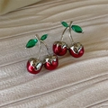 Elegant red cherry stud earrings with green crystal leaves on a soft textured fabric background - Silver Base Cherry (E2938)