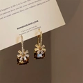 Macro detail of French style earrings with brown square crystal and zircon floral accents - Amber Cube Zircon Flower Style