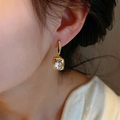 French vintage gold earrings with sparkling square crystal worn by a female model - Heartbeat Edges (E1352) / Gold / White Zirconia