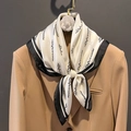 Elegante sciarpa in seta con scritte nere e bordo abbinata a un abito kaki - 70*70cm / Beige