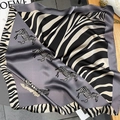 Detail shot of silk square scarf featuring realistic zebra print and animal motif borders - Dark Gray