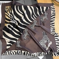Close-up of silk square scarf with zebra print and brown borders on lifestyle background - Coffee