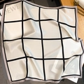 Dettaglio del foulard in seta a scacchi con finitura satinata e bordo a spina di pesce - 65*65cm / Beige
