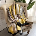 Elegante sciarpa in seta gialla con motivi a orchidee e geometrie su un divano - 90cmx180cm / Giallo
