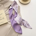 Detail of a purple floral silk twilly scarf with elegant script lettering on a blazer - Dandelion Purple