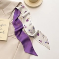 Detail of French style floral Twilly scarf tied as elegant neckwear on a beige blazer - Flower Rice Purple
