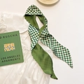 Dettaglio di una sciarpa di seta a scacchi verdi su una camicetta bianca a balze - Scacchi Verde Patchwork