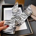 Détail du foulard à motif zébré avec lettrage GRACE sur un plateau de présentation - 8*100CM / Beige-Noir