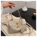 Close-up of cream faux leather handbag featuring dual golden rectangular twist-lock closures - Small / Light Gray