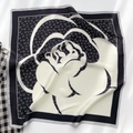 Dettaglio macro di un foulard in seta bianco e nero con elegante motivo a fiori di camelia - 65*65cm / Beige-Nero