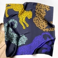 Dettaglio di un foulard in seta blu scuro con stampa leopardata su un trench coat - Stampa ghepardo / Blu navy