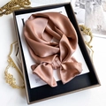 Close-up of a rose gold silk scarf tied in a bow on a fashion book with pearl luster - 15*150cm / Dusty Pink