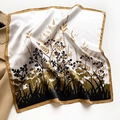Close-up of silk square scarf with floral silhouette print and golden hem on a trench coat - Ginger Edge