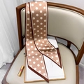 Foulard sottile a pois marrone e bianco presentato su una sedia in pelle di lusso - Cachi