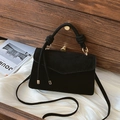 Matte black crossbody bag with knotted handle and gold metal rings on white fabric - Black