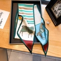 Foulard en soie avec motifs de chevaux et rayures vertes sur table en bois - Rouge