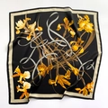 Dettaglio ravvicinato di un foulard in seta 70x70cm con motivi di iris gialli su nero - Specificazione Quadrata / Nero (Motivo Iris)