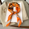 Hermès-style orange silk scarf with equestrian belt patterns on a beige blazer - New Orange