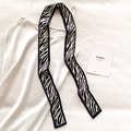 Close-up of zebra print narrow silk scarf on elegant white satin dress fabric - Black and White Zebra Stripe (DT-16)