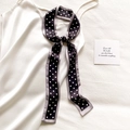 Dettaglio di un foulard sottile a pois annodato con stile su un abito di raso bianco - 5.5*118cm / Nero